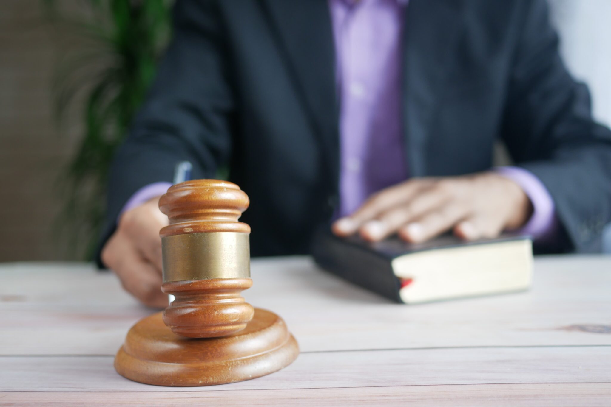 Individual in a suit with a judicial gavel on a table by towfiqu-barbhuiya